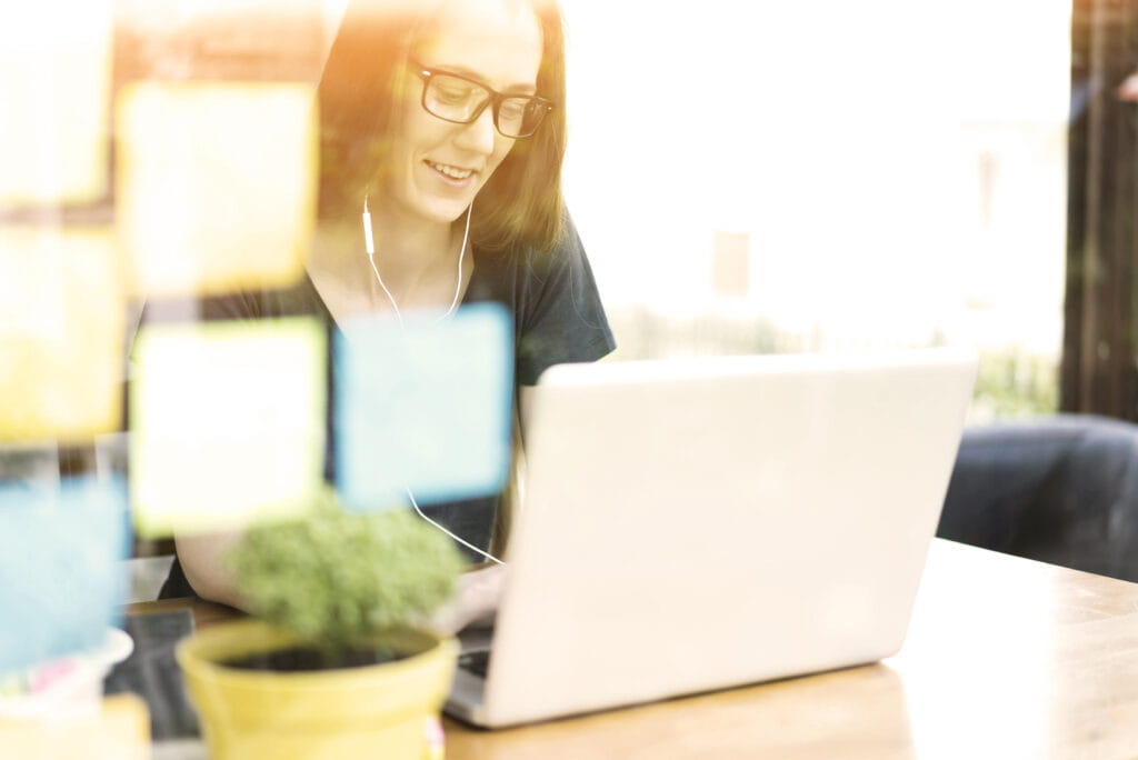 Woman sitting at a desk with sticky notes in front of her.