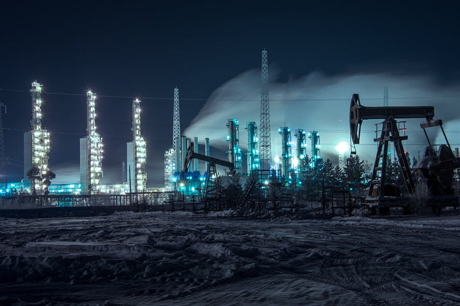 Brightly lit oil rigs at night.