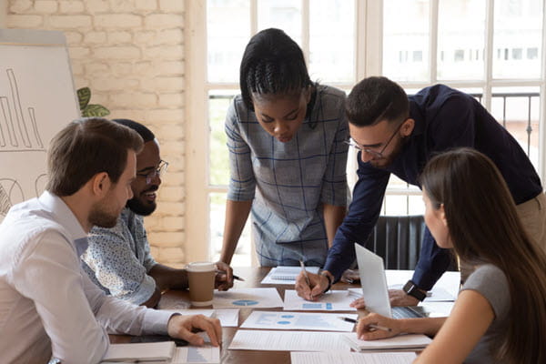 A diverse group of professionals going over paperwork together.