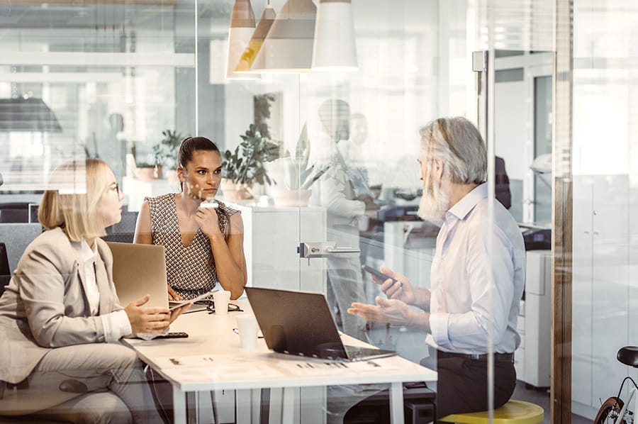 Two women and a man in a meeting room