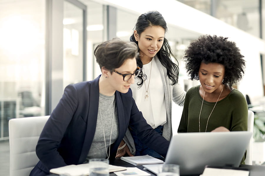 Women coworkers looking at a laptop screen 