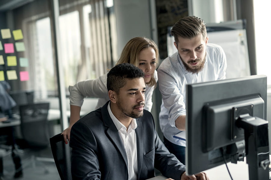 Coworkes looking at a computer screen in an office space