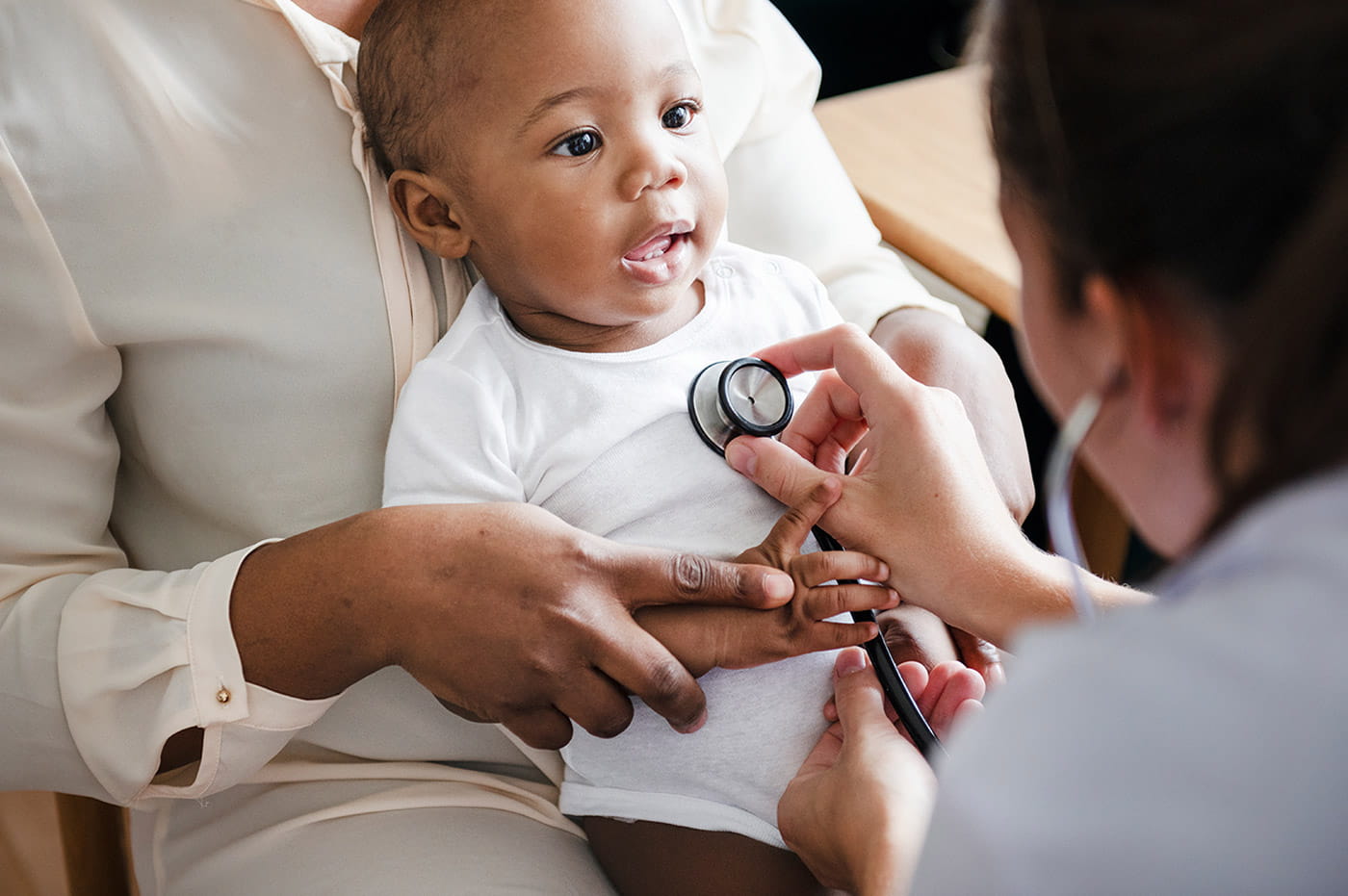 Doctor listening to a baby's heartbeat using a stethoscope.