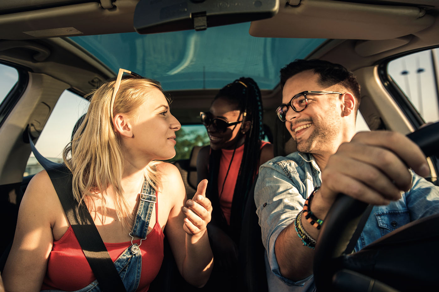 3 people sitting inside a car