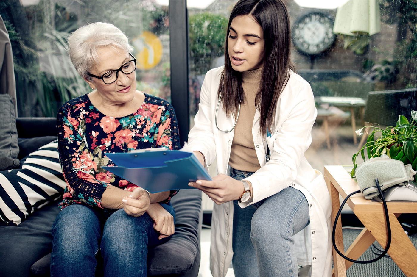 A doctor and older patient going over information on a clipboard together.