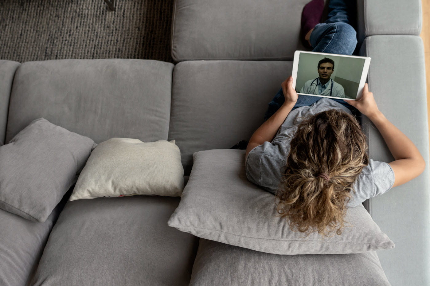 A woman on a tablet device talking to a doctor